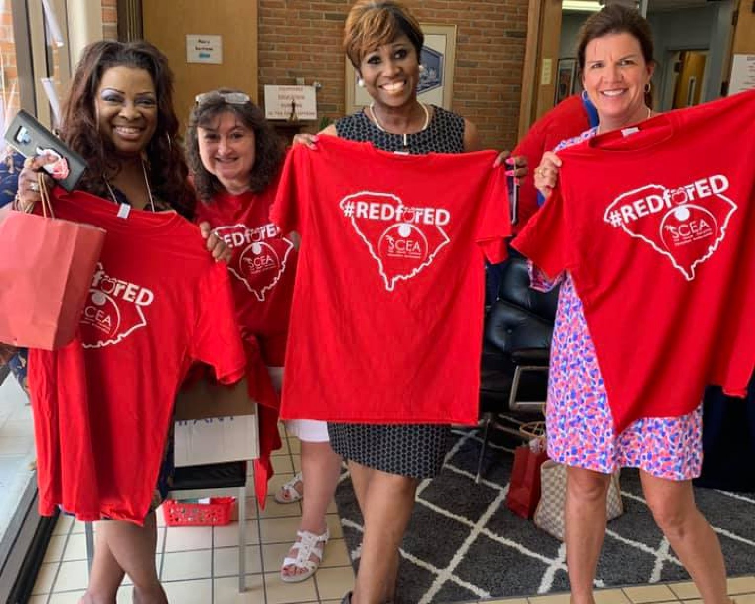 Members pose with Red for Ed shirts.