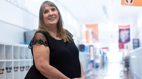 Laura Warren stands in her school's hallway looking over her right shoulder