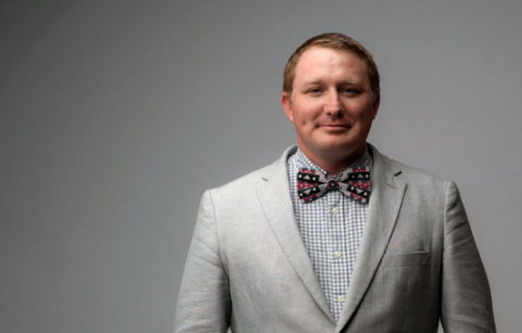 NEA member Alex Red Corn, wearing a suit jacket and bow tie.